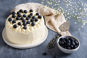 blueberry cake with cream cheese and fresh berrries on dark background. Copy space
