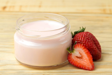 delicious strawberry yogurt in a jar and fresh ripe strawberries on a natural wooden table