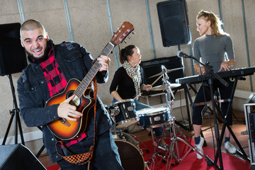 Bearded guy soloist playing guitar in studio