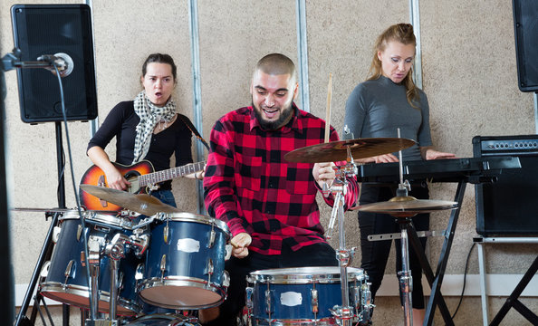 Rehearsal of music group with male drummer