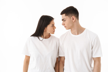 Angry young couple standing isolated over white background