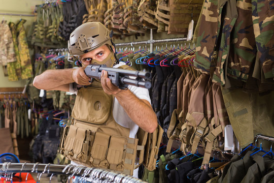 man in army uniform with weapon in military market