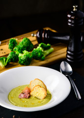 Broccoli cream soup with bread on a table. Classic European food