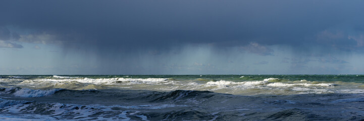 Waves on the Baltic Sea against dark blue dramatic thunderclouds