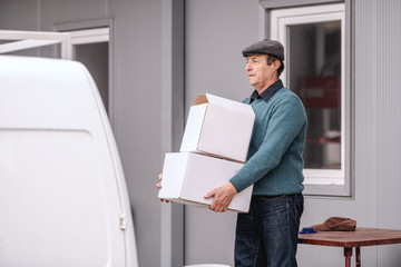 Caucasian peasant carrying boxes he want to send.