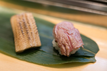 two sushis on the leaf covered table
