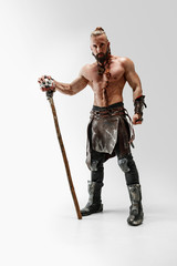 Serious long hair and muscular male model in leather viking's costume with the big mace cosplaying...