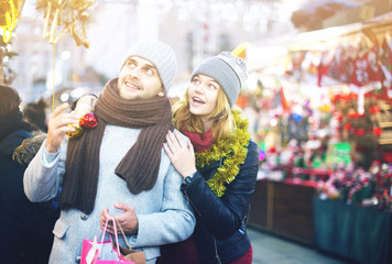 Girl with boy delighted with purchases at  Christmas market