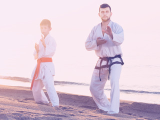 Naklejka premium Man and boy exercising karate