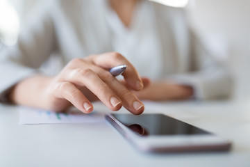 business, technology and people concept - close up of hand of businesswoman using smartphoner at office