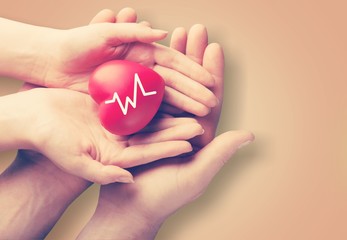 Man and woman holding red heart in