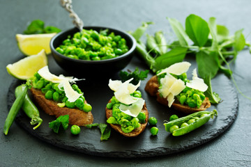 Crostini with pea puree, mint and parmesan. Snack.