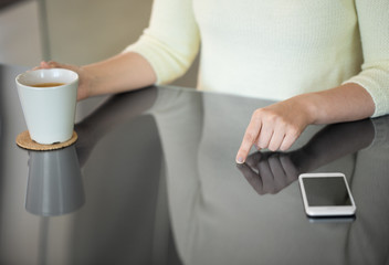 technology and people concept - close up of woman using black interactive panel and drinking coffee