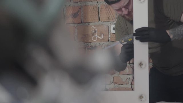 Carpenter putting together furniture details with glue. Concept of hand manufacturing. Craftman works in a workshop.