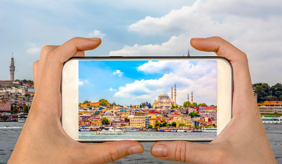 Tourist taking a picture in front of   Golden Horn against Galata tower, Istanbul, Turkey 