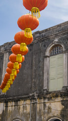 Fototapeta na wymiar Red lamp lanterns hanging on top of a street during Chinese New Year in Penang, Malaysia