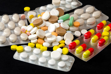 Color pills with blister on a dark background. Medicine and health. Vitamins.