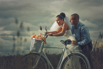 Vintage wedding. Groom and bride on a bicycle