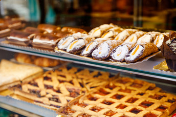 Sweet homemade cannoli stuffed with ricotta cheese cream and pistachial Sicilian dessert at market...