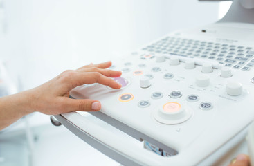 Gynecologist preparing her ultrasound for an examination pregnant woman.