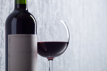 Bottle and glass of red wine .