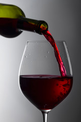 Red wine is poured from a bottle into a glass.