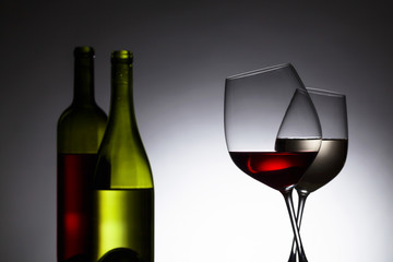 Bottles and glasses with red and white wine.