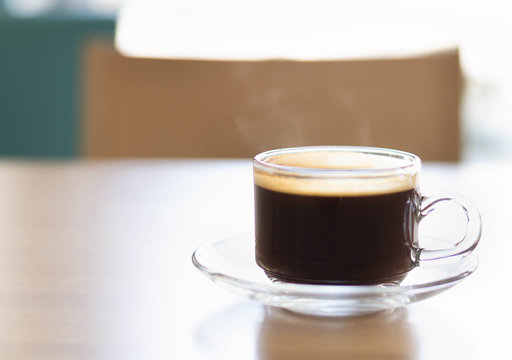 Closeup glass of hot americano coffee on wood table, selective focus, vintage tone