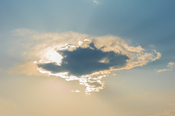The sun shines behind the cloud