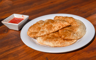 Traditional Tatar pastry Chiburekki aka Cig borek on wooden table, Eskisehir, Turkey.