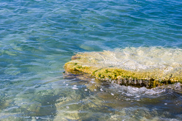 rocky sea shore with pebble beach, waves with foam