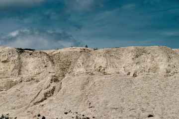 white limestone quarry on a background of blue sky with clouds
