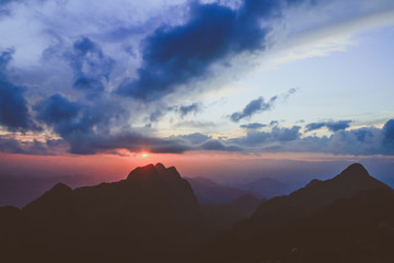 Sunset in sky and cloud, beautiful colorful twilight time with silhouette of mountain.