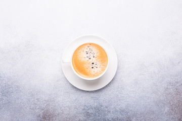 Cup of coffee on stone background. Office workplace. Top view
