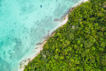 Aerial drone top view of the beautiful lagoon sea surface and tropical paradise island with white sand
