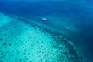 Fototapeta na wymiar Aerial drone view of boats over amazing lagoon crystal clear sea water with coral reef, Thailand