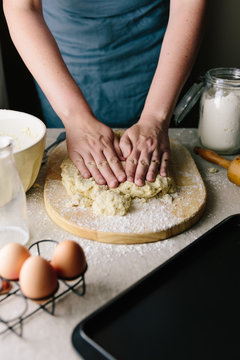 Woman using hands to flatten dough for scones