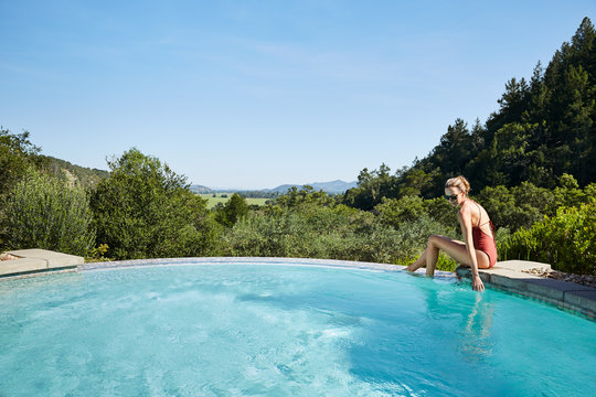 Beautiful mature woman at spa pool touching water
