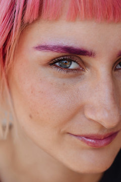 Woman with pink hair and eyebrows