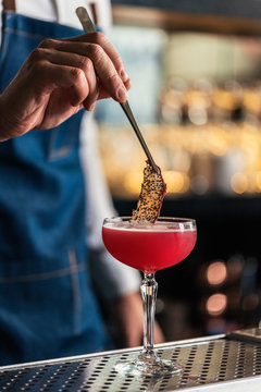 Unrecognizable professional young bartender working