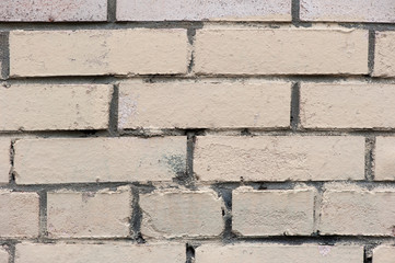 Old painted beige color weathered stained brick wall