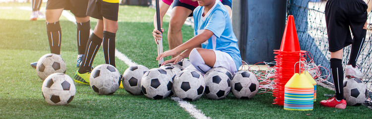 id soccer player and coach are pump air in to a football. © Koonsiri