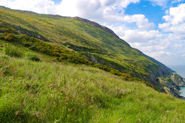 Rolling green hills and cliffs in Wicklow, Ireland with Irish sea on right