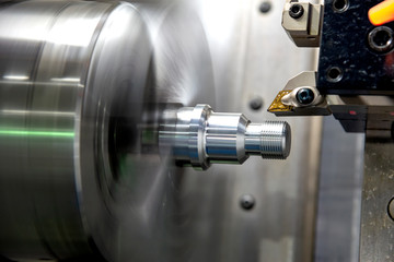 The CNC lathe machine cutting the thread    at the metal parts. The hi-technology automotive parts...