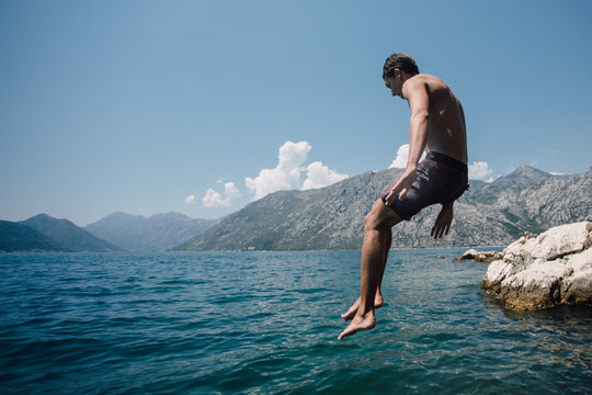 Young man jumping in to water