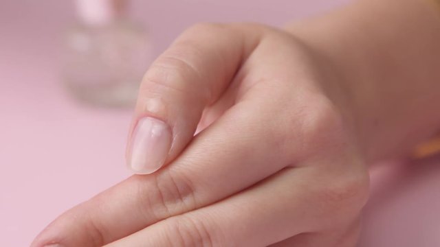 closeup oil drop falling on cuticle zone and other hand massage a cuticle
