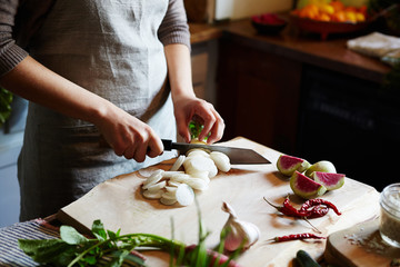 Woman chopping daikon while cooking