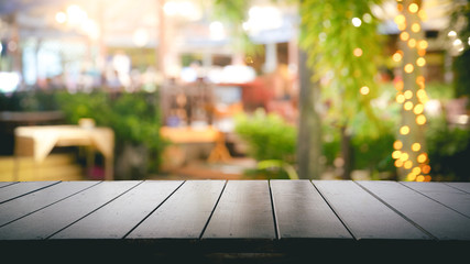 Empty wood table top and Blur light reflection on scene at restaurant, pub or bar at night.