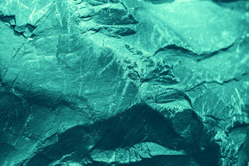 Vintage azure background. Rough painted wall of turquoise color. Imperfect plane of cyan colored. Uneven old decorative toned backdrop of aqzure tint. Texture of teal hue. Ornamental stony surface.