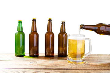 Glass and bottle of beer with no logos on wooden table isolated copy space, bottle mock up. Beer bottle studio shot with cap isolated.
